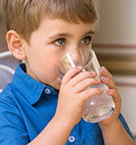 Kid drinking BC Orchard coconut water—naturally sweet from young coconuts.
